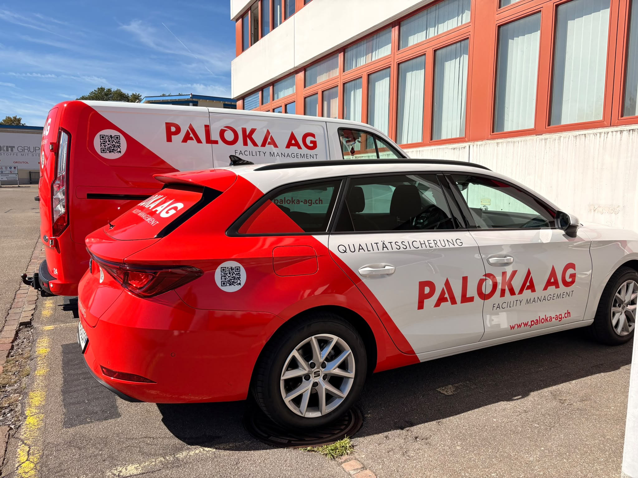 Paloka-Fahrzeug mit der Beschriftung Qualitätssicherung und Servicebus vor einer Gewerbeliegenschaft in Otelfingen.
